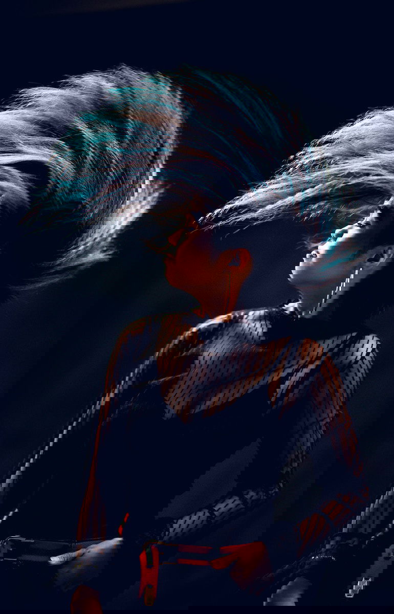 A woman flipping her head and long blue hair up