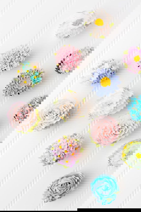 Overhead shot of flowery frosted cakes against a light background