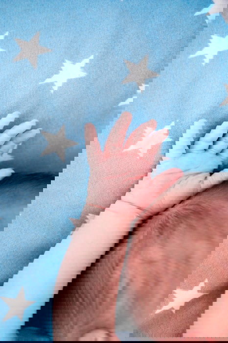 Baby's hand and arm on blue blanket as an idea for newborn photos