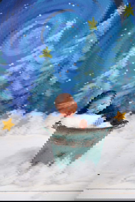 Newborn in a bucket in a snow scene as an example of newborn photo ideas